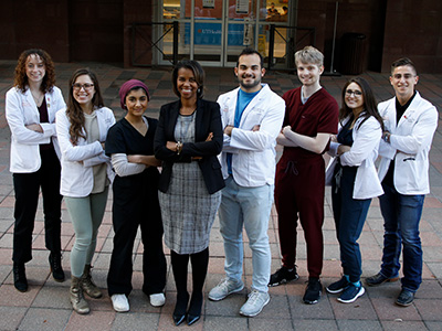 Dr. LaTanya Love standing with students at the entrance to McGovern Medical School