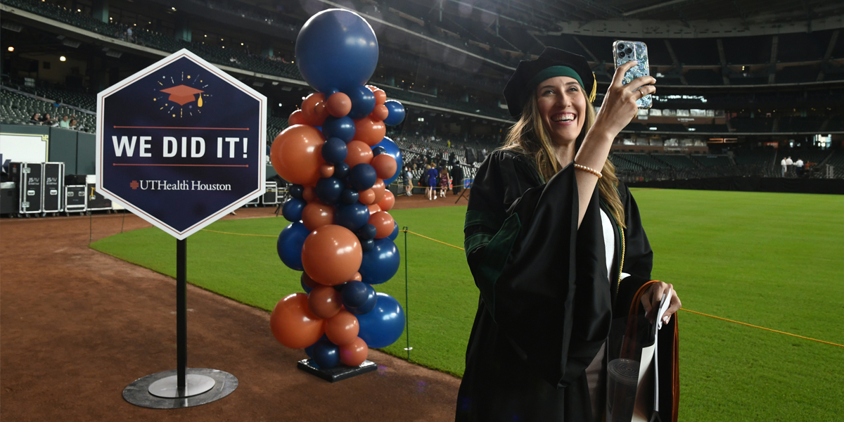 Homepage banner photo of a graduate taking a selfie at UTHealth Houston graduation