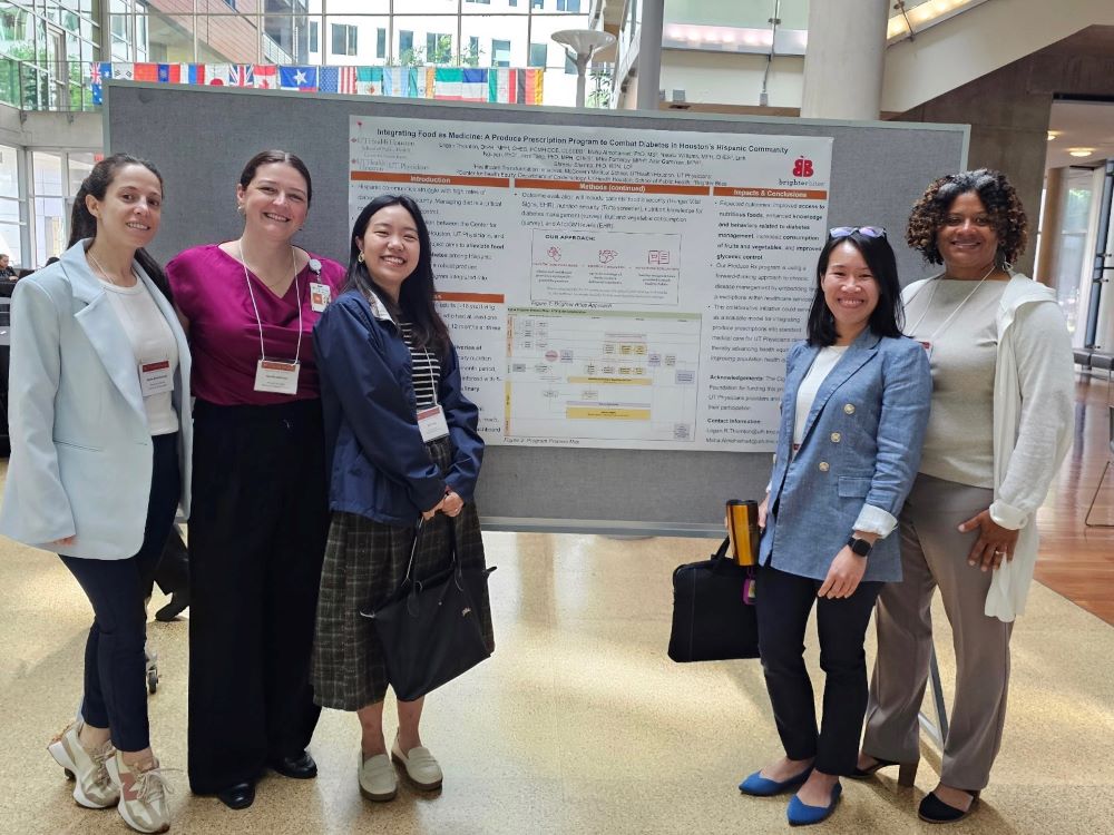 Academic research team posing around research poster.
