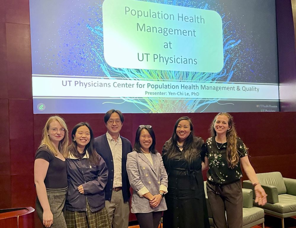 Team of UT Physicians center for Population Health Management and Quality posing in front of presentation