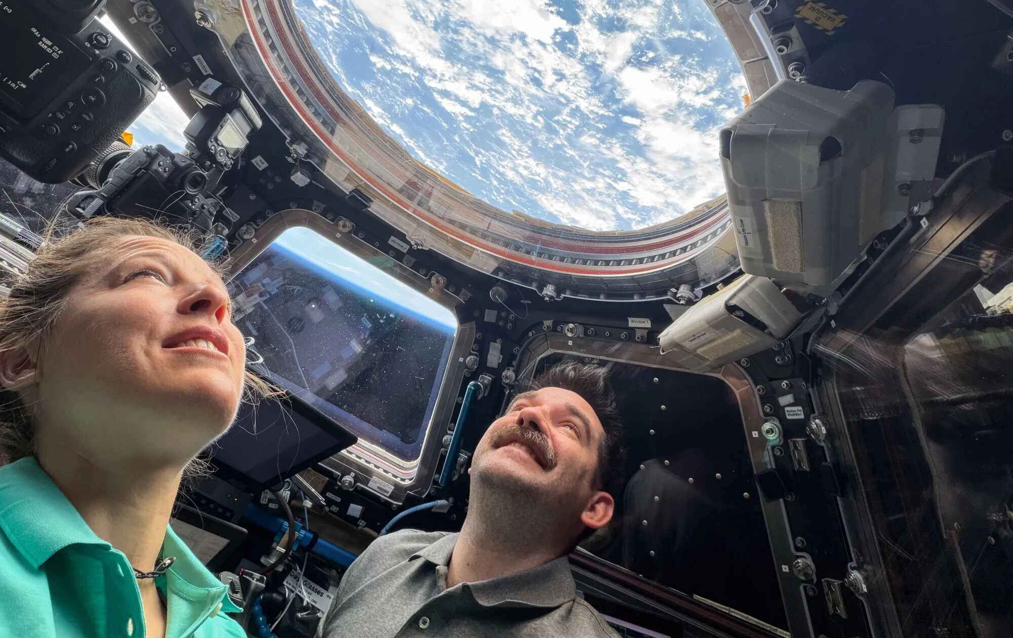 astronauts in space looking out window
