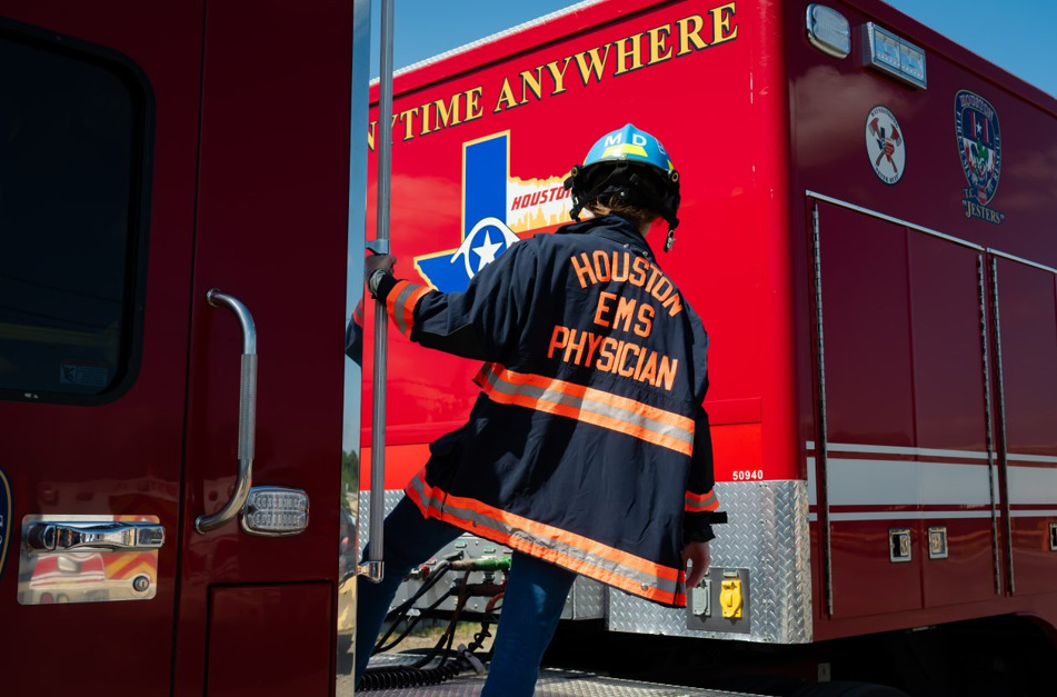 Intern hanging off firetruck