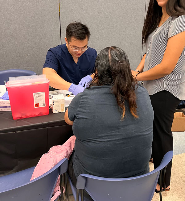 student volunteers screening patients blood pressure