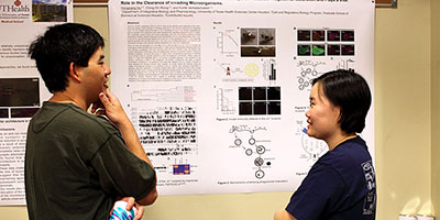 two people talking in front of poster