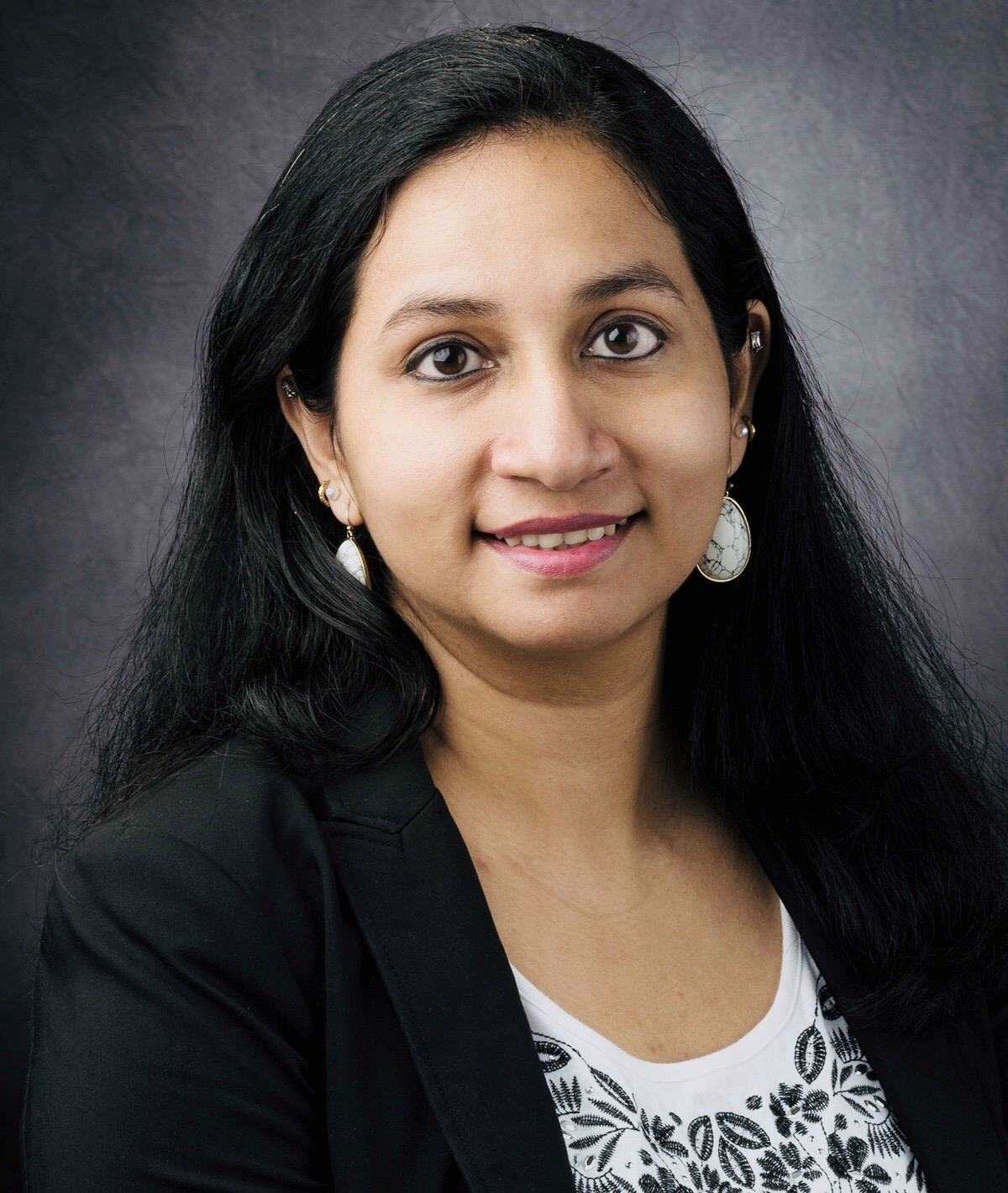 A long black hair woman is smiling.