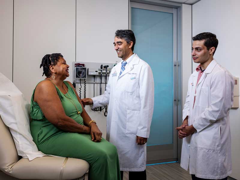 Social Connections - Two doctors in a clinical setting talking with a patient