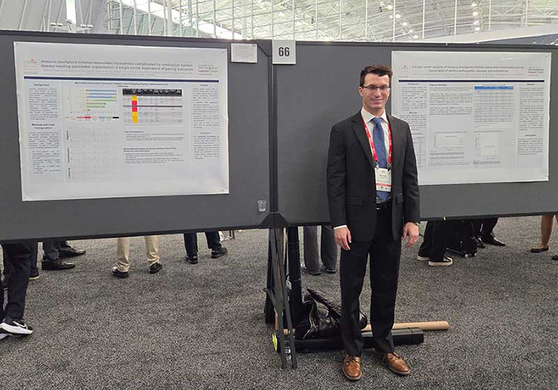 Dr King presenting his posters simultaneously at HRS 2024