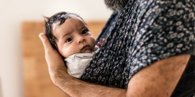 man holding dark haired baby