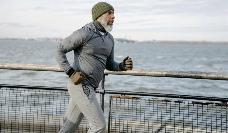 Senior African American male jogging on bridge