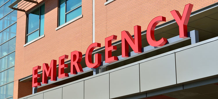 Emergency in red letters on a red brick hospital building