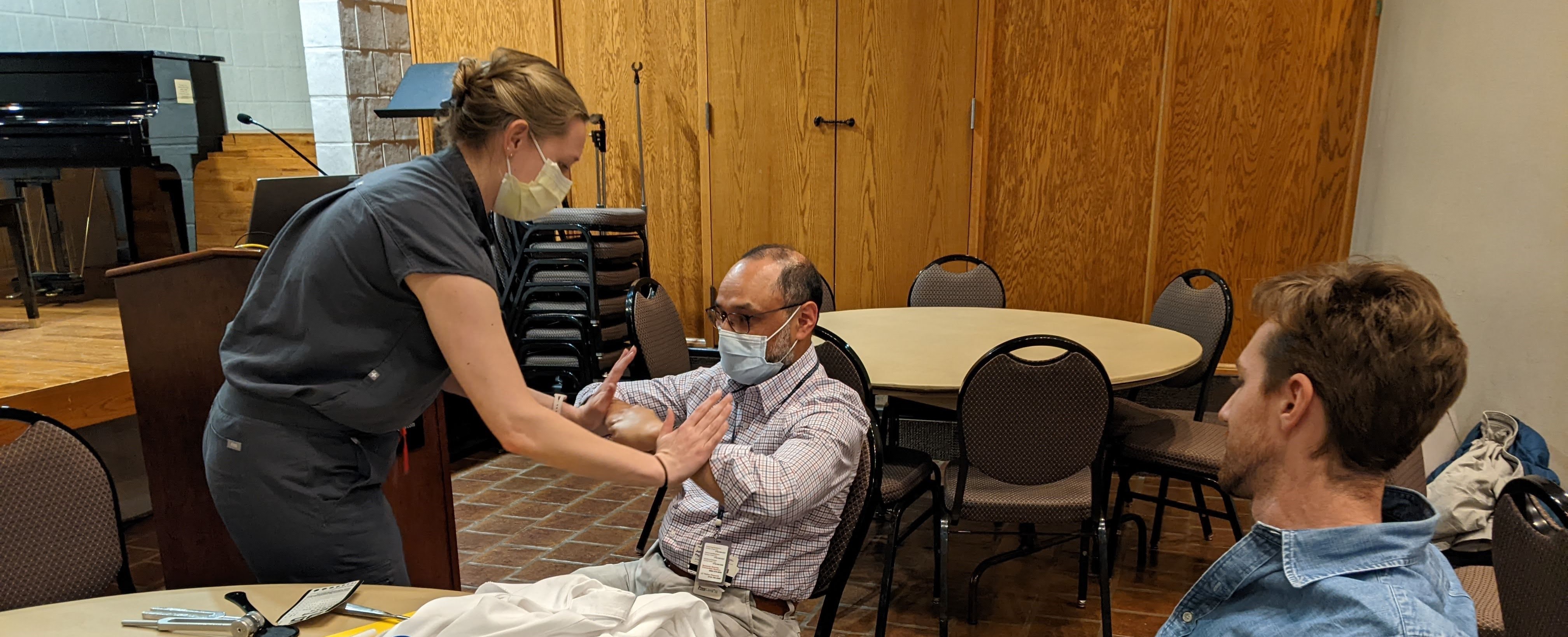 Resident Dr. Herbst demonstrating physical exam on Dr. Lincoln
