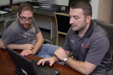 IT technician helping student with their computer.