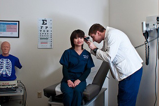 Student practicing physical diagnosis skills in LRC practice room.