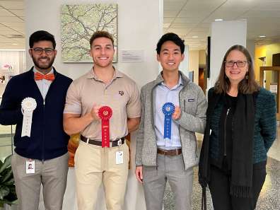 C. Frank Webber Prize winners holding white, red and blue award ribbons