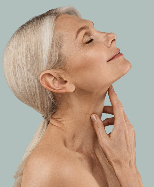 white woman with light hair touching her neck