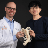 Dr. Borden and Kai Weir together holding 3D Spine