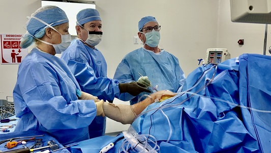 Eric Berkman, M.D. (right), performs a knee replacement in the operating room. (Photo provided by Dr. Berkman)