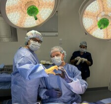 William Harvin, M.D. (right), and his surgical assistant make a heart with their hands after finishing a trauma case. (Photo provided by Dr. Harvin)