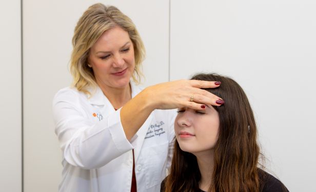 Summer Ott, PsyD, performs a concussion evaluation on a young patient during a clinical examination at UTHealth Houston.
