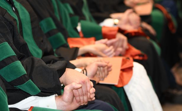 2026 McGovern Medical School graduates holding hands during the commencement speech