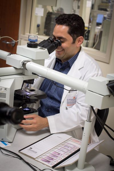 Student looking through microscope while on pathology student rotations.