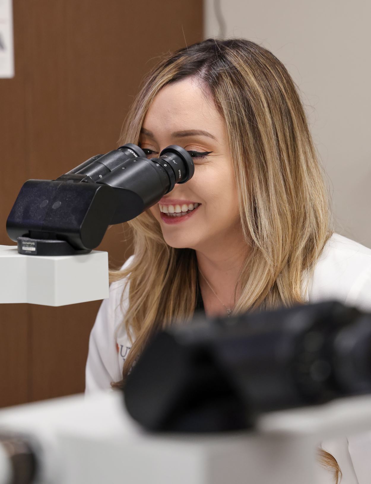 Student looking through microscope while on pathology student rotations.