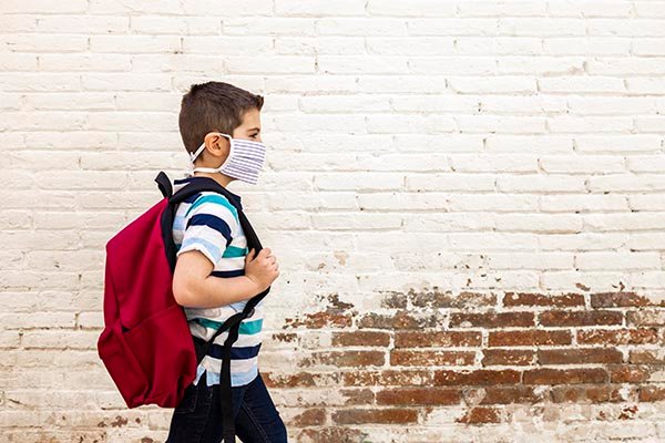 Image of boy walking with backpack. (Photo credit: Getty images)
