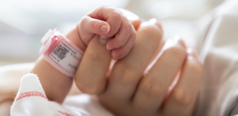 newborn holding their parent's finger
