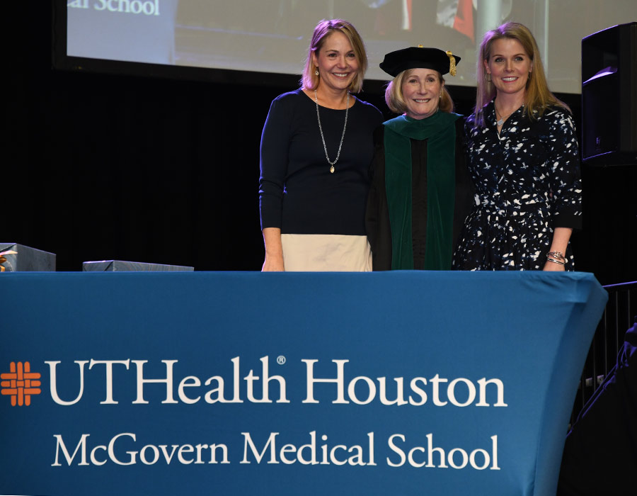 Margaret McNeese, MD, is joined by her daughters Catherine and Bridget after receiving the Distinguished Service Award at the 2023 Commencement Ceremony. (Photo by Dwight Andrews/Office of Communications)