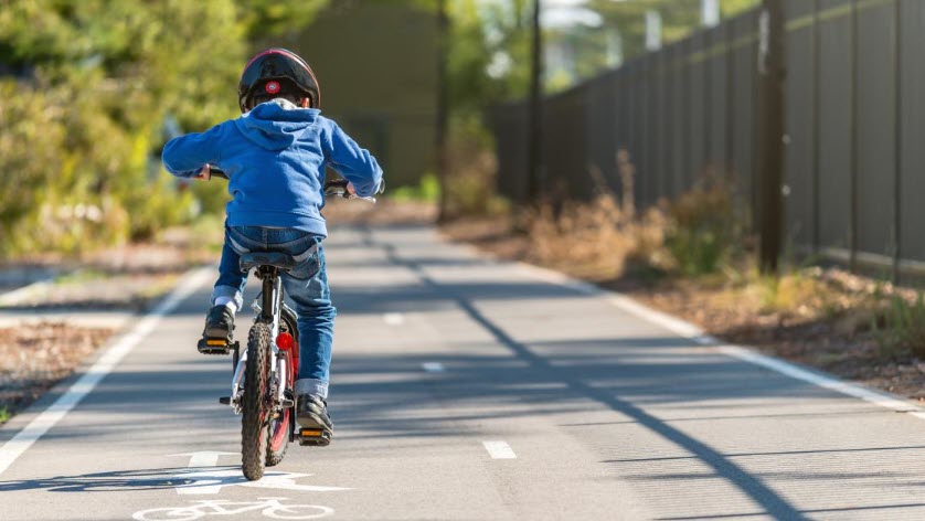 child rides bike on a safe pathway