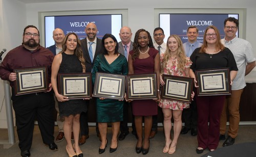 Inductees pose with their plaques