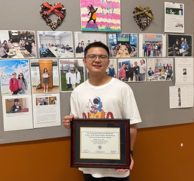 Mingjie Zheng posing with award