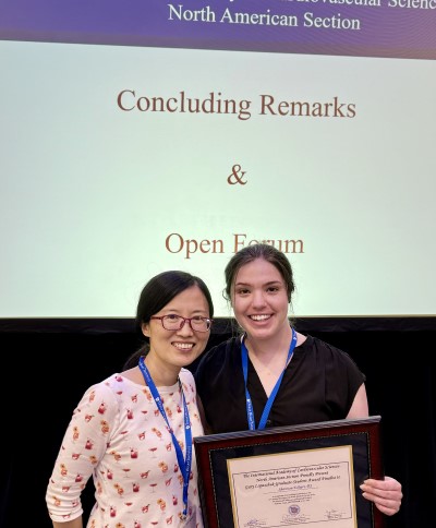 Shannon Erhardt holds award with mentor Jun Wang