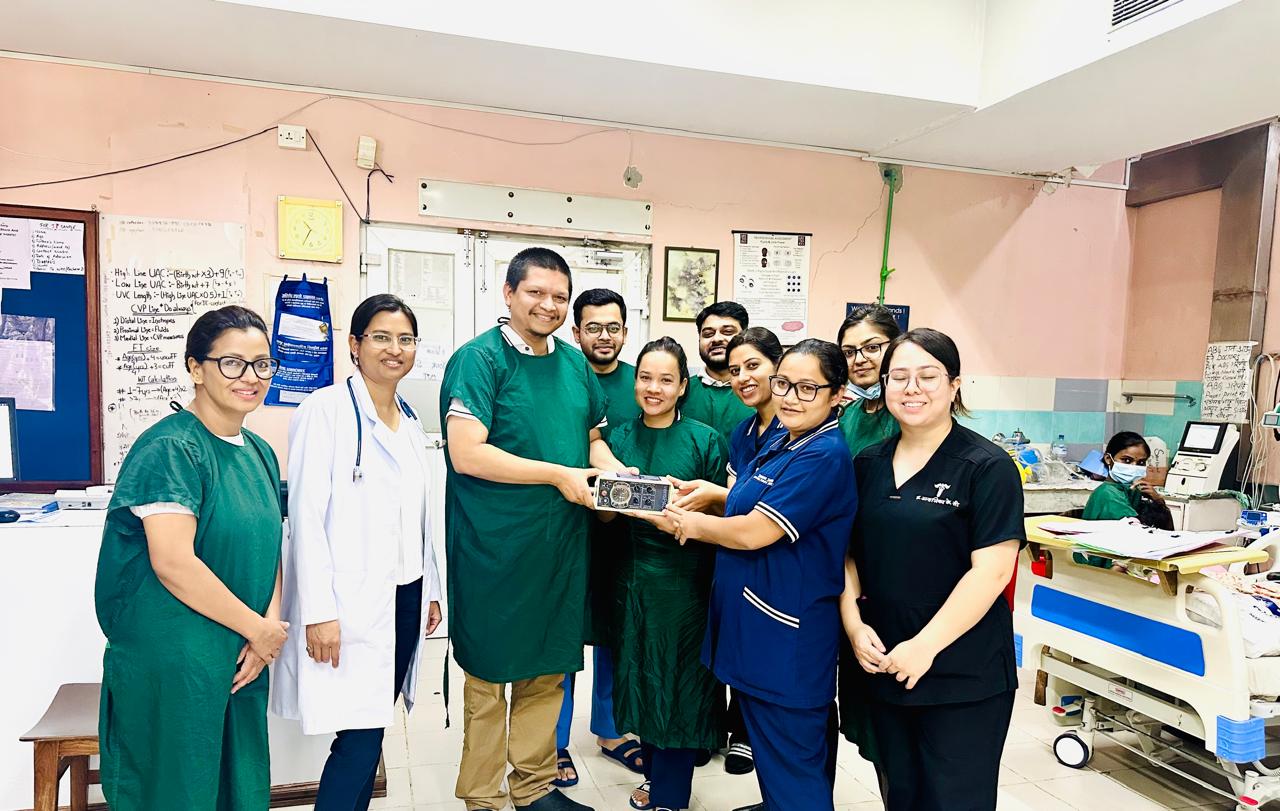 Dr. Bista hands gift to team at Patan Hospital in Nepal