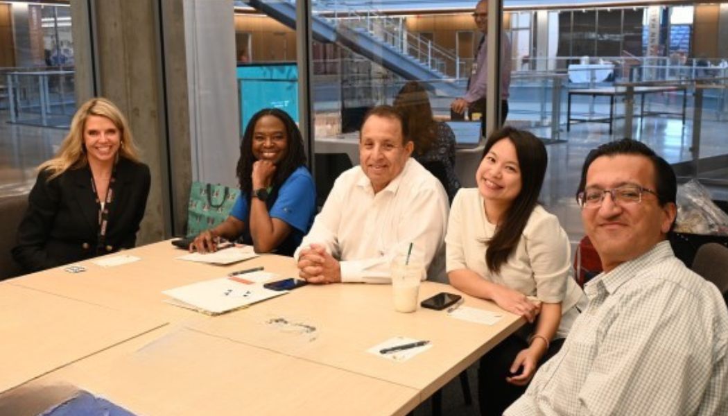 Doctors smiling and talking around a table