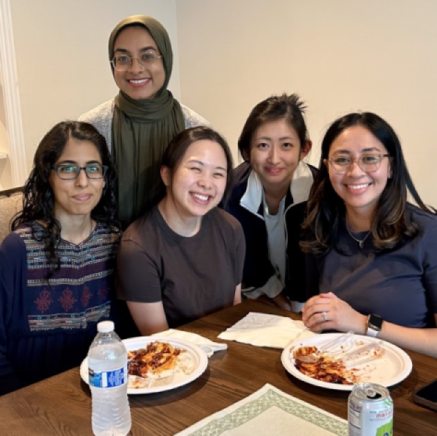 Five smiling women around a table