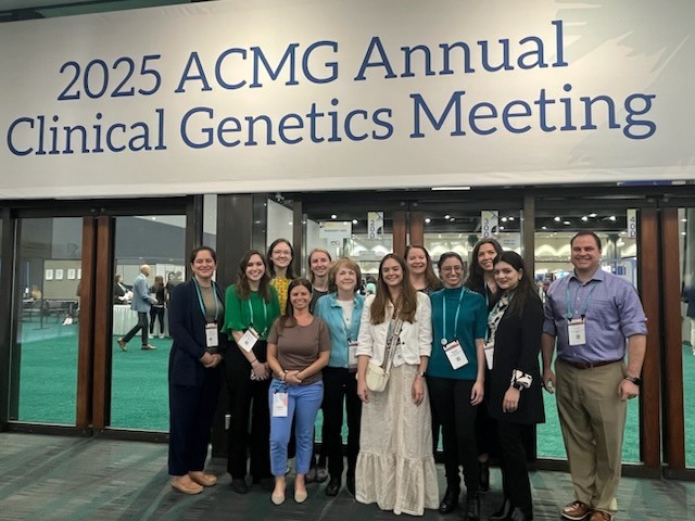 Group of people standing under a conference banner