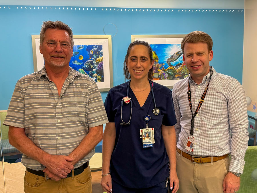 Three health professionals in front of blue wall