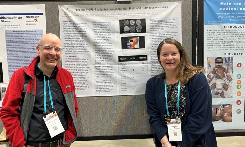 Two people standing in front of research poster