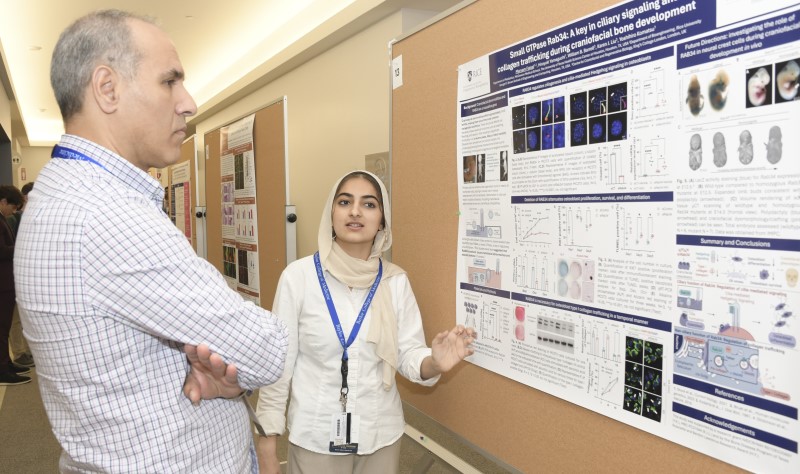Maryam presenting poster to attendee