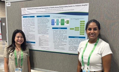 Two doctors in front of research poster
