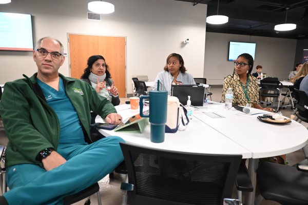 People around a table listening to presentation