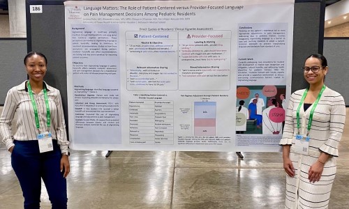 Two doctors in front of research poster