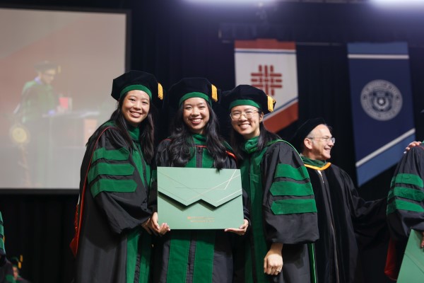 Three doctors in graduation robes and hats