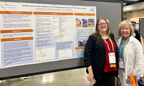 Two doctors in front of a research poster