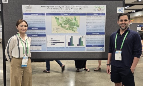Two people standing in front of research poster