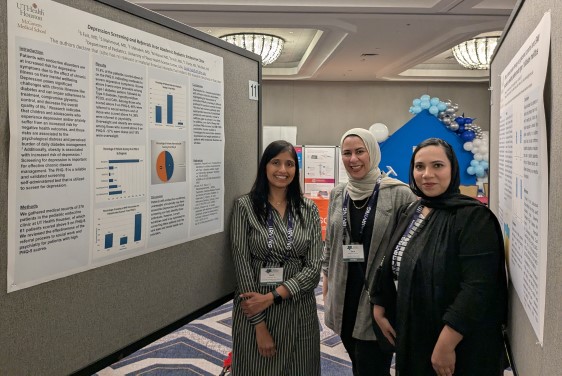 Three doctors standing near two research posters