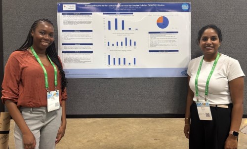 Two doctors standing in front of research poster