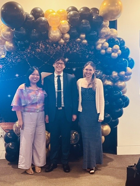 Three doctors standing in front of balloon arch