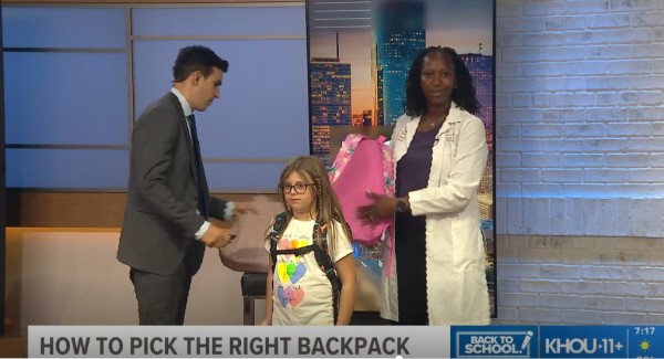 Man and woman helping little girl with backpack